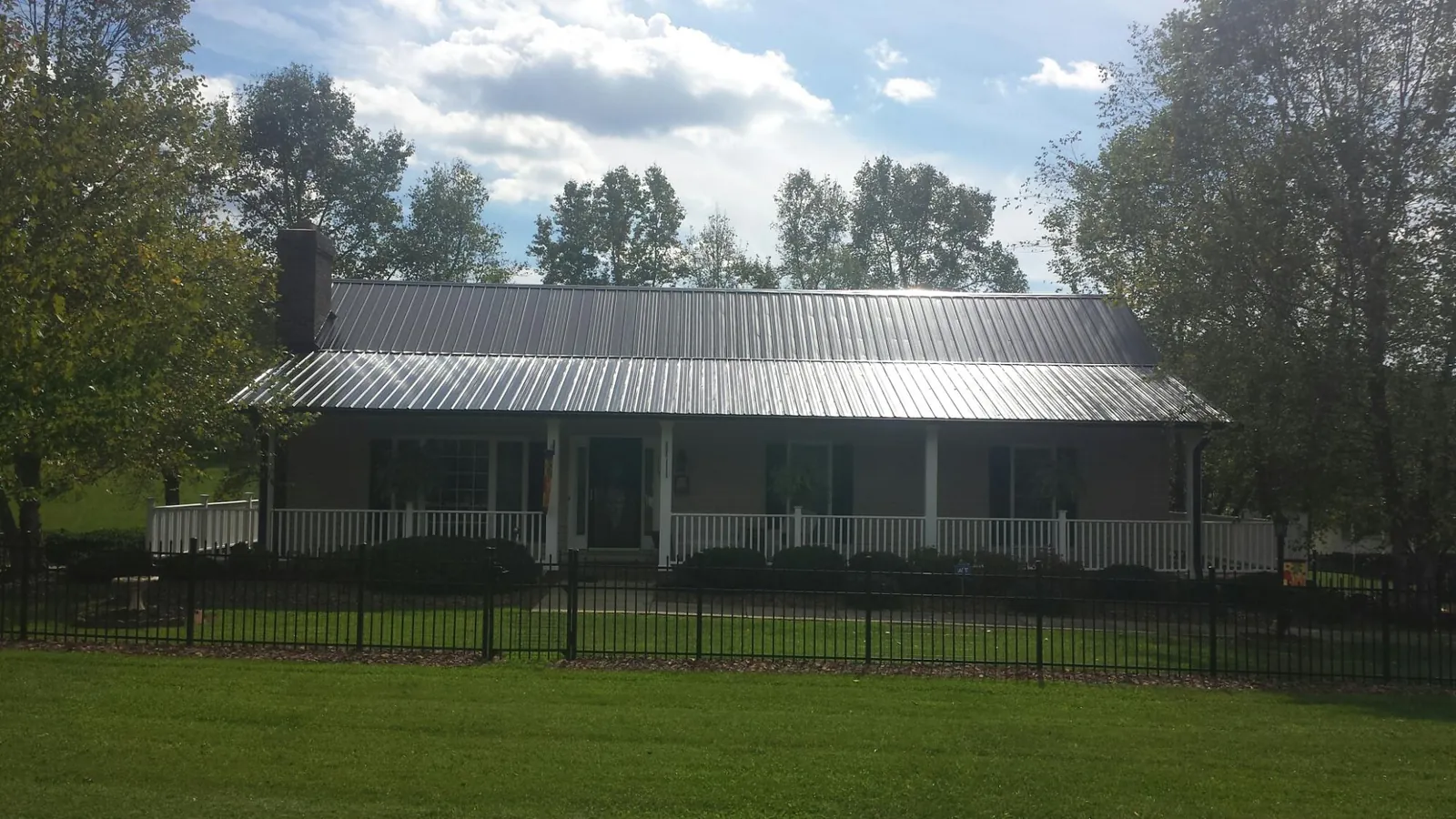 Gray metal roof on a brick ranch with a full width front porch — Gutter Guard Installation work by our crew in Fultonham