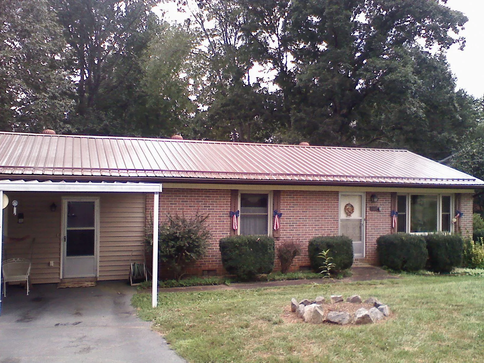 Bronze metal roof and carport on a brick ranch home — Roof Repair work by our crew in Fultonham